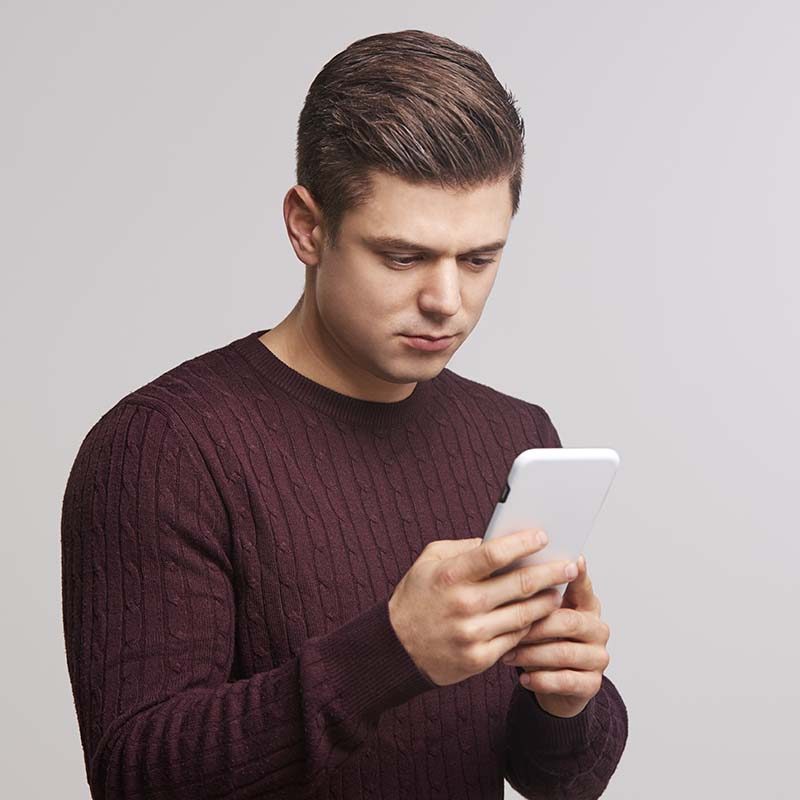 portrait-of-a-young-white-man-using-a-smartphone-PBFJNAY.jpeg